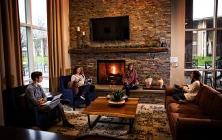 A group of students sitting in the common room of their residence hall.